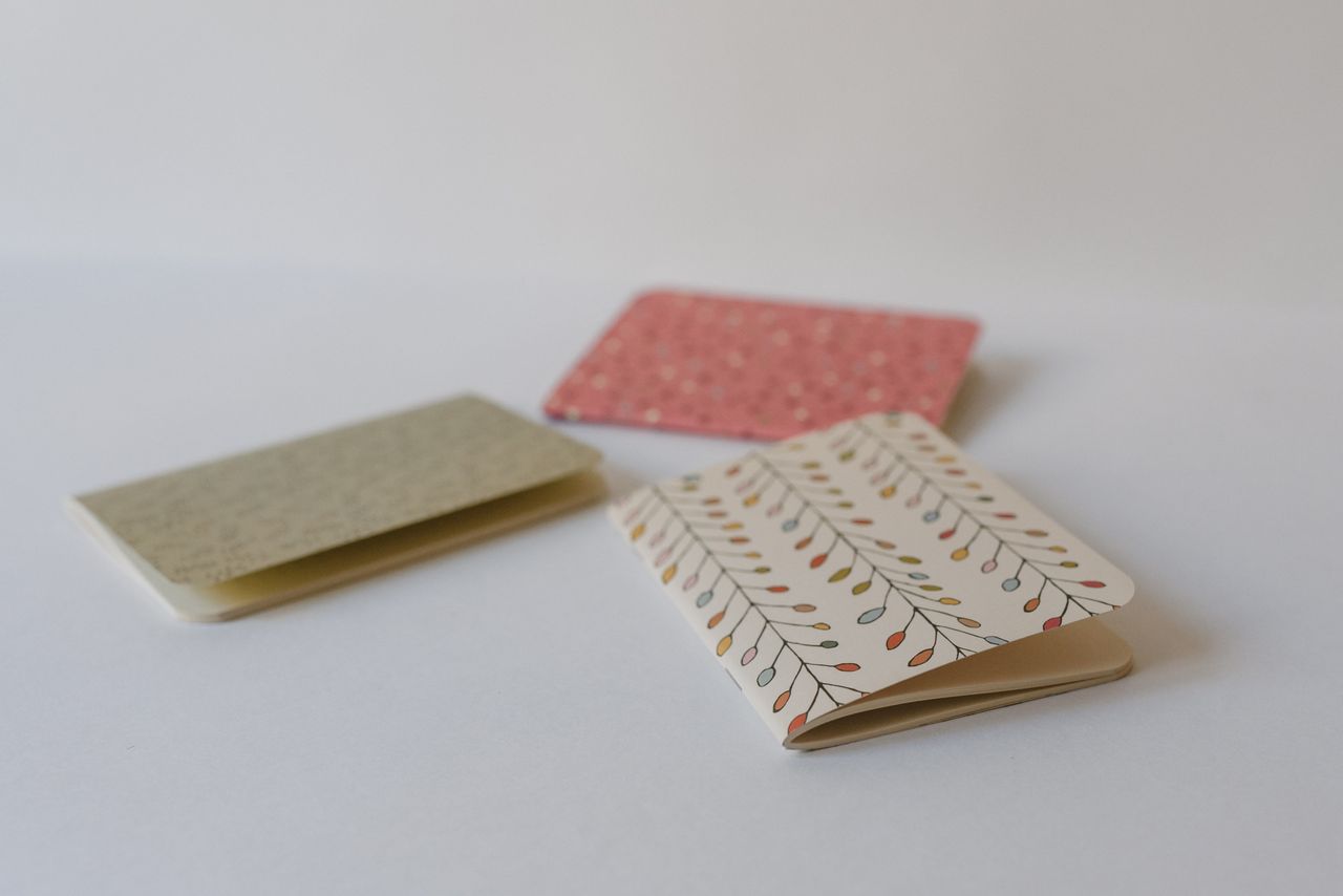 Three decorative notepads featuring various colorful patterns on a white surface.