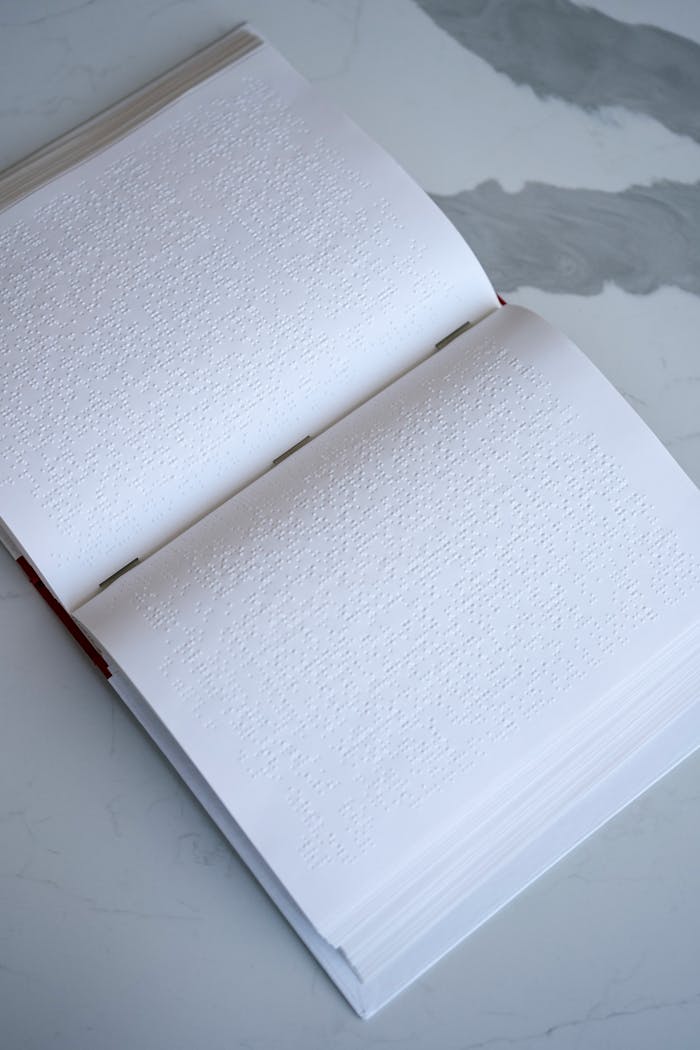 A close-up of an open Braille book on a marble surface, highlighting accessibility.